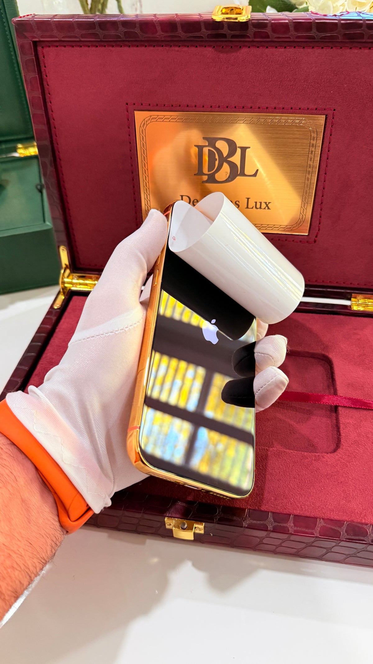 Reflective front screen of a gold-finish phone with protective film