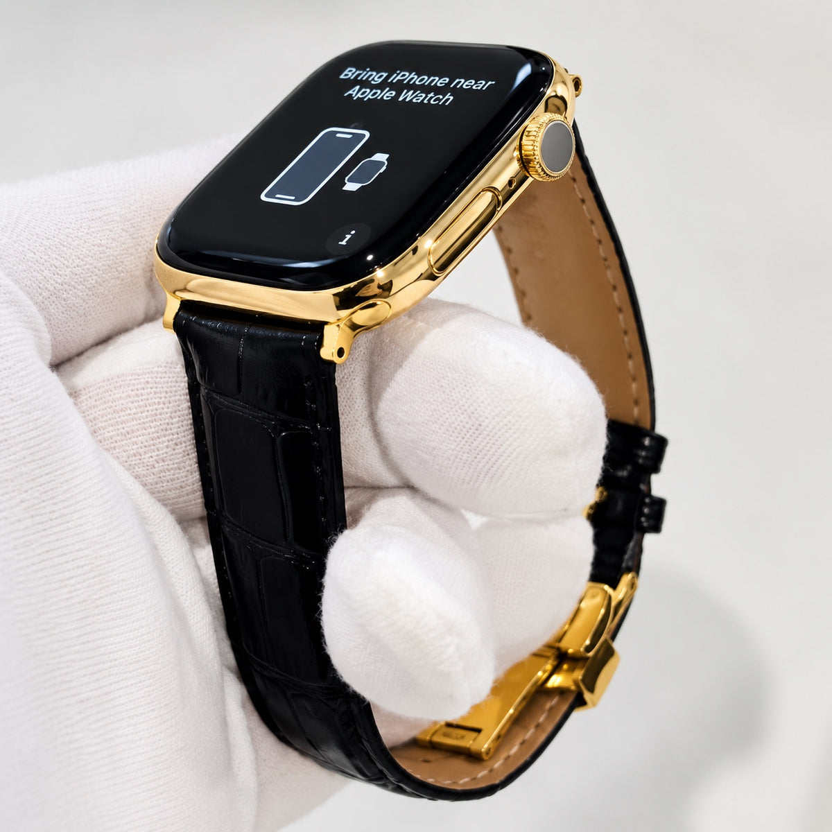 Custom Apple Watch Series 12 with 18K gold finish and black alligator leather band, front three-quarter view