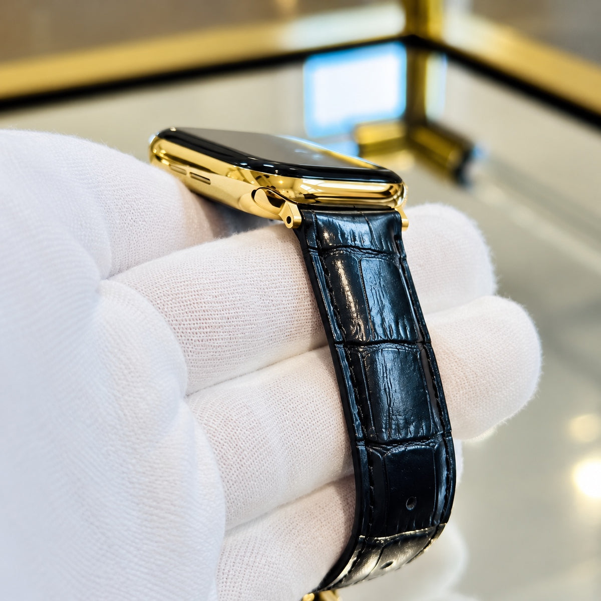 Low-angle detail of the polished 18K gold Apple Watch Series 12 case and black alligator leather band