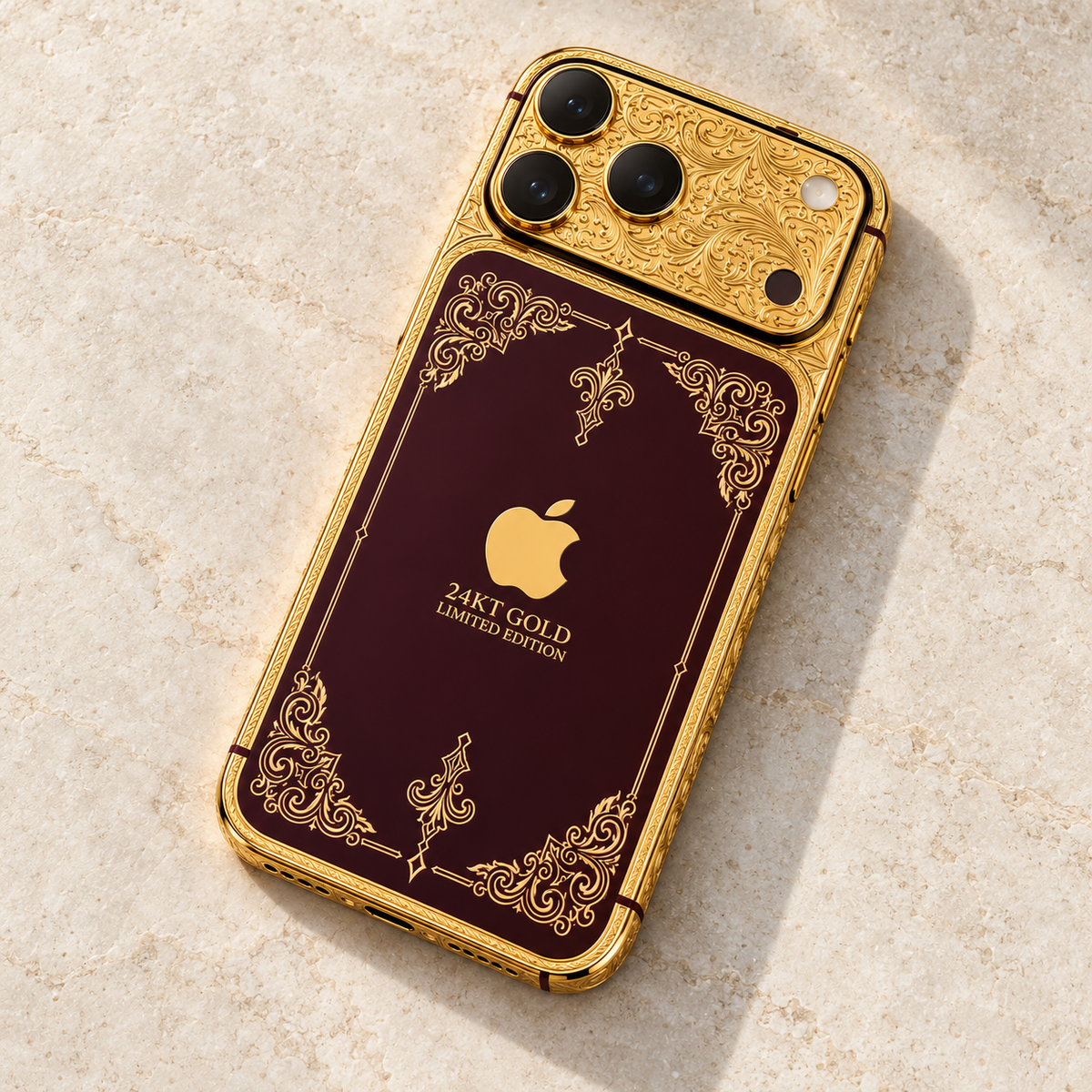Custom iPhone 18 Pro Max in 24K gold and burgundy, diagonal rear view on cream stone