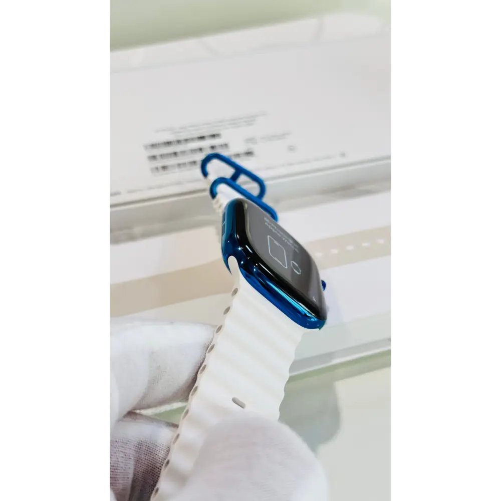 Polished blue Apple Watch with a white band; finish reference. The listing identifies the included band, case size and selected generation.