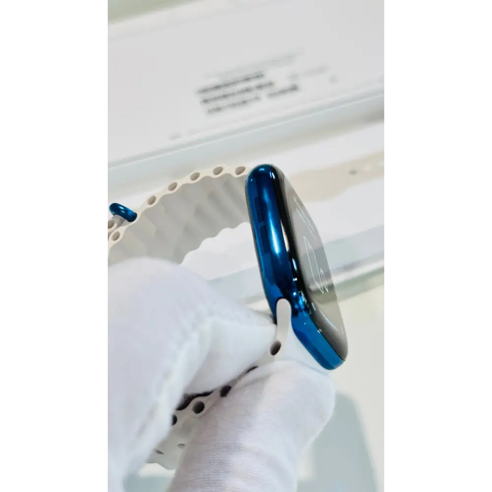 Polished blue Apple Watch with a white band; finish reference. The listing identifies the included band, case size and selected generation.