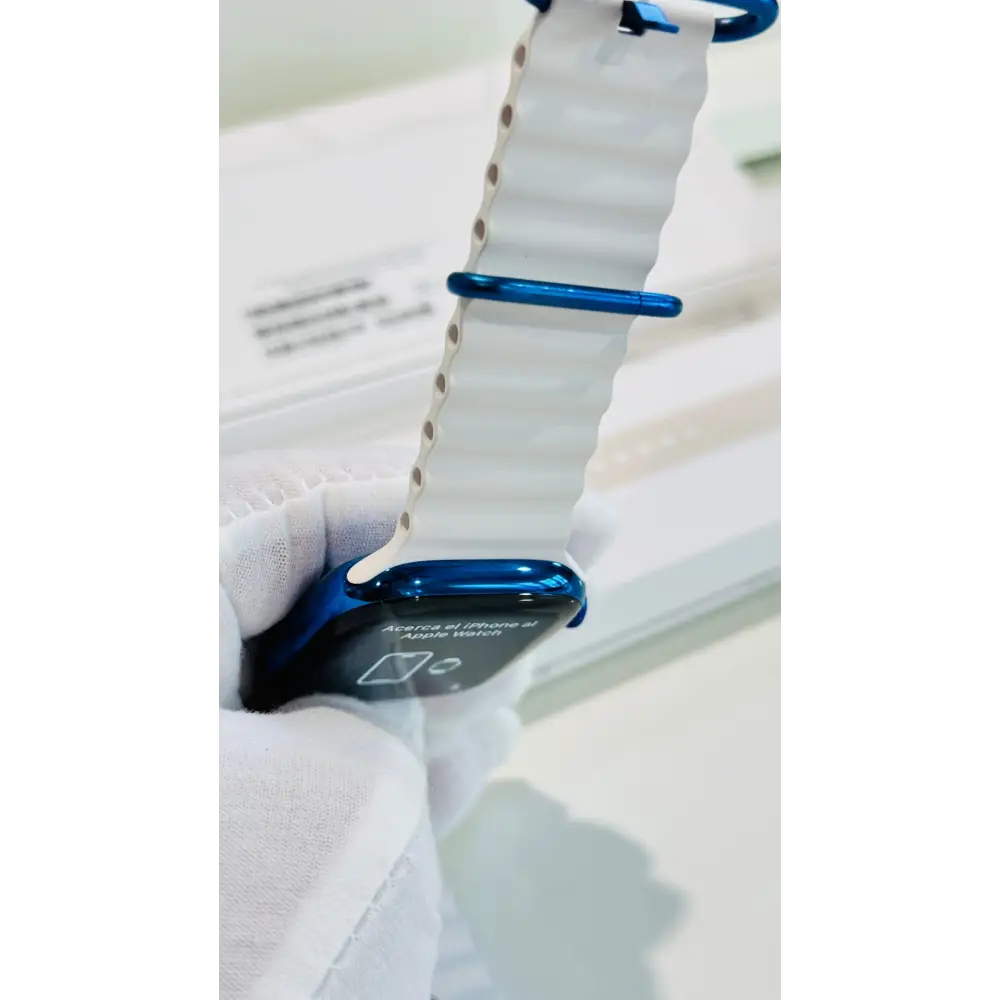 Polished blue Apple Watch with a white band; finish reference. The listing identifies the included band, case size and selected generation.
