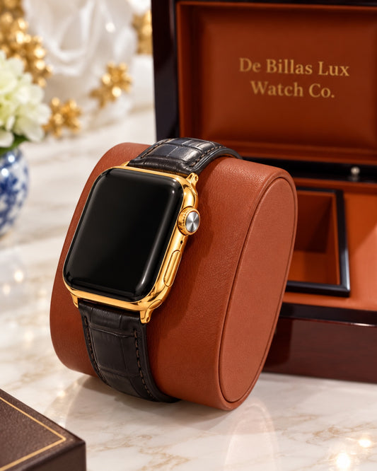 Custom 24K gold-plated Apple Watch Series 9 with black leather band on a brown cushion beside the De Billas Lux box
